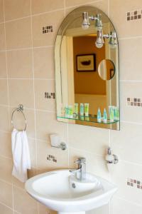 a bathroom with a sink and a mirror at Ballyheigue Cliff Side and Sea View Apartment in Ballyheigue