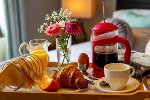 una mesa con una bandeja de alimentos para el desayuno y una cafetera en Ballyheigue Cliff Side and Sea View Apartment, en Ballyheigue