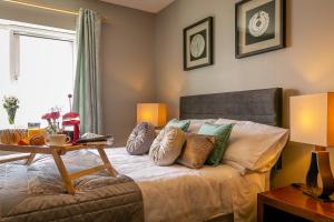 Schlafzimmer mit einem Bett mit Kissen und einem Tisch in der Unterkunft Ballyheigue Cliff Side and Sea View Apartment in Ballyheigue