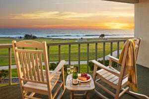 a dining room table with chairs and a balcony overlooking the ocean at Cavalier Oceanfront Resort in San Simeon