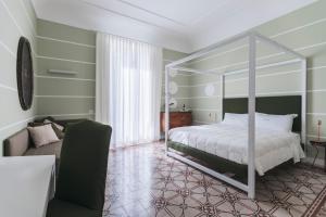 a bedroom with a canopy bed and a couch at Euterpe LHT in Agrigento