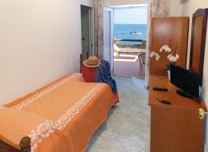 a bedroom with a bed and a television and a balcony at Hotel La Gondola in Ischia