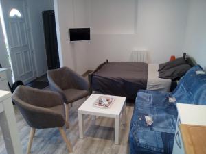 een kamer met een bed en een tafel en stoelen bij Studio neuf tout confort très calme in Beuvrages