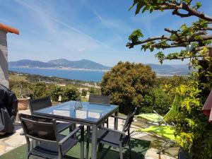 - une table avec des chaises et une vue sur l'eau dans l'établissement A Mandria, à Porticcio