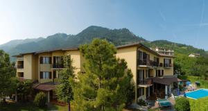um resort com piscina e montanhas ao fundo em Hotel Astra em Tignale