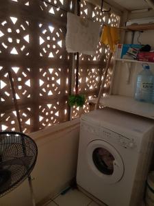 a laundry room with a washing machine and a window at appartementsurlaplage in Saly Portudal