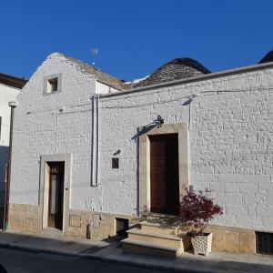 アルベロベッロにあるAlberobello Casa Vacanze - Pathos tra i Trulliの白レンガ造りの建物(ドア、階段付)