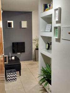 ein Wohnzimmer mit einem Sofa und einem Fernseher an der Wand in der Unterkunft Bello Departamento 2 Habitaciones, Barrio Norte in San Miguel de Tucumán