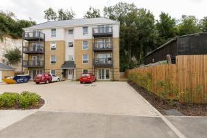 an apartment building with a car parked in a parking lot at Hertford Serviced Apartments by Payman Club in Hertford