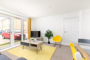 sala de estar con mesa y TV en Hertford Serviced Apartments by Payman Club, en Hertford