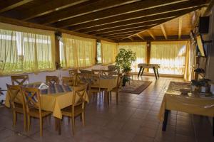 a dining room with tables and chairs and windows at Villa Benice in Morino