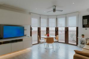 a living room with a tv and a table and chairs at Apartamento de Esther y Javi in Elche