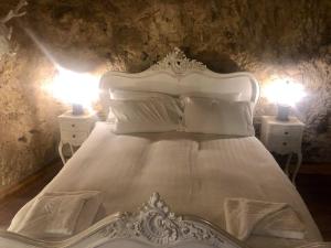 a bedroom with a white bed with two lamps at The Grotto in South Shields