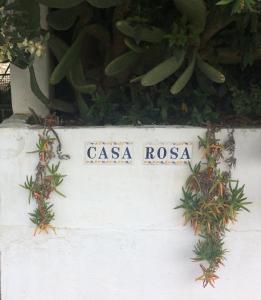 een bord voor casa rosa op een muur met planten bij Casa La Rosa in Almedinilla