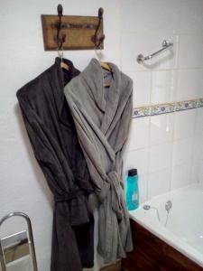 een badjas aan een muur naast een bad bij Casa La Rosa in Almedinilla