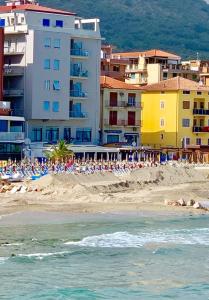 una spiaggia con un gruppo di ombrelloni e edifici di Vela d’Oro a Pietra Ligure