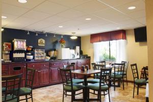 a restaurant with tables and chairs and a kitchen at Best Western Richland Inn Mansfield in Mansfield