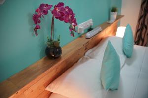 バア環礁にあるFaima Fishing Lodge at Daravandhooの紫の花瓶付きベッド