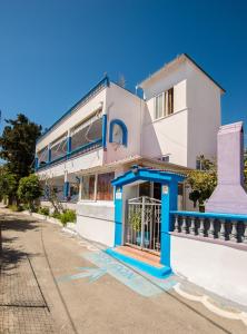 a white and blue building with a gate at Poseidon Apartment in Archangelos