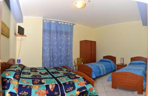 a bedroom with two beds and a television in it at Villa Benice in Morino