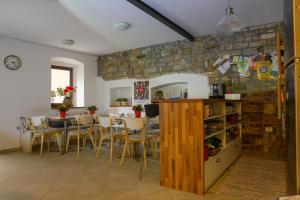 a dining room with a stone wall and a table and chairs at Hostel Alieti in Izola