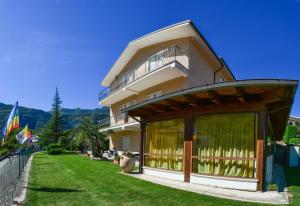 a large building with a balcony and a yard at Villa Benice in Morino