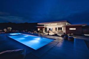 ein großer Swimmingpool vor einem Haus bei Nacht in der Unterkunft SkyHouse in Joshua Tree