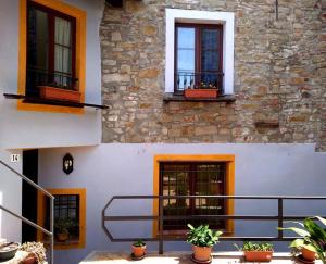 a building with windows and potted plants in front of it at B&B Il Campo dei Papaveri in Mornese