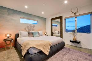 Schlafzimmer mit einem großen Bett und Fenstern in der Unterkunft SkyHouse in Joshua Tree + 30 Fotos
