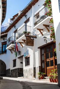 a white building with balconies and plants on it at Hotel La Fragua I in Trevélez