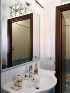 a white bathroom with a sink and a mirror at You Welcome Apt in Elmas