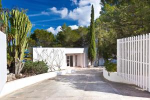 a white fence in front of a white house at VILLA CAN HERMANOS: Wifi gratis, piscina privada y vistas al mar in Sant Josep de Sa Talaia