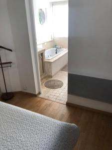 Un baño con bañera y ventana. en Villa des iris, en París