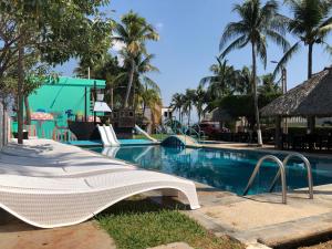 a large white swimming pool sitting next to a beach at Hotel Villa Murano in Puerto Arista