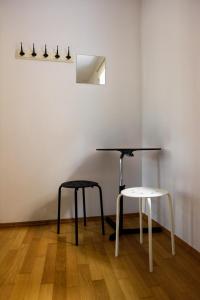 a table and two stools sitting in a room at Hostel Alieti in Izola