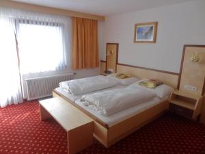 Un dormitorio con una cama grande y una ventana en Pension Schöpf, en Arzl im Pitztal