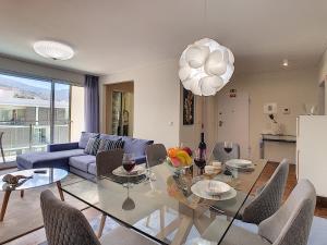 ein Wohnzimmer mit einem Glastisch und einem blauen Sofa in der Unterkunft Gardenia Apartment by LovelyStay in Funchal