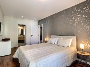 ein Schlafzimmer mit einem Bett und einer Wand mit Blumen darauf in der Unterkunft Gardenia Apartment by LovelyStay in Funchal