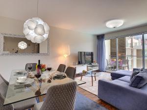 ein Wohnzimmer mit einem Tisch und einem blauen Sofa in der Unterkunft Gardenia Apartment by LovelyStay in Funchal