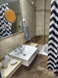 ein Badezimmer mit Waschbecken, Spiegel und Badewanne in der Unterkunft Bello Departamento 2 Habitaciones, Barrio Norte in San Miguel de Tucumán