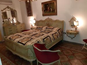 カルタニッセッタにあるCasa rosyのベッドルーム(ベッド1台、椅子、鏡付)
