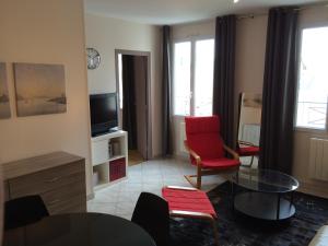 a living room with a red chair and a tv at Rouen Quartier St Maclou in Rouen