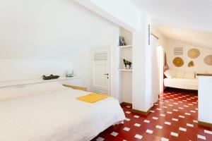 Un dormitorio blanco con una cama y un sofá. en Casa a 10m dal Mare, en Palau