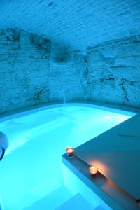 uma banheira de hidromassagem com luzes azuis num quarto em Trulli Occhi Di Pietra em Alberobello