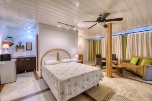 a bedroom with a bed and a living room at CariPro Apartments in Puerto Viejo