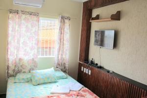 a bedroom with a bed with a mirror and a tv at Pousada Renascer II in Cachoeira Paulista