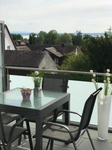 d'une table et de chaises sur un balcon avec vue. dans l'établissement Seeblick Ferienwohnung Bodensee, à Friedrichshafen