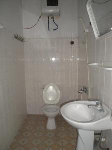 a white bathroom with a toilet and a sink at Phuong Mai Family Hotel in Cat Ba