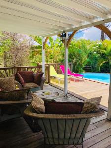 a patio with a table and chairs on a deck at Sunshine Villa in Le Moule