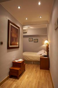 1 dormitorio con 1 cama y 1 mesa con mesita de noche en Hotel Juanito en La Roda